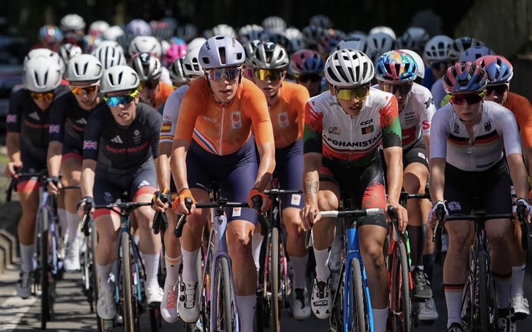 Netherlands' Ellen Van Dijk (center L) and Afghanistan's Yulduz Hashimi (center R) cyle at the front of the pack of riders (peloton) during the women's cycling road race during the Paris 2024 Olympic Games in Paris, on August 4, 2024. (Photo by Li Yibo / POOL / AFP)