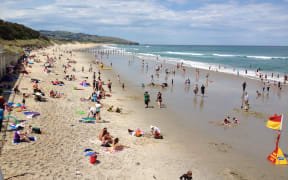 People flock to Dunedin's St Clair Beach as temperatures pass 30 degrees Celsius