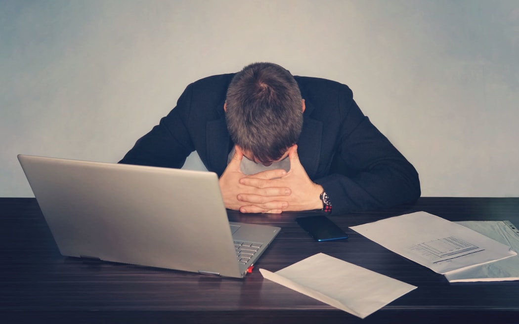 Exhausted tired businessman working on laptop at office, massaging temporal area, holding glasses, feeling fatigue discomfort, eye strain after long wearing spectacles, eyesight problem,