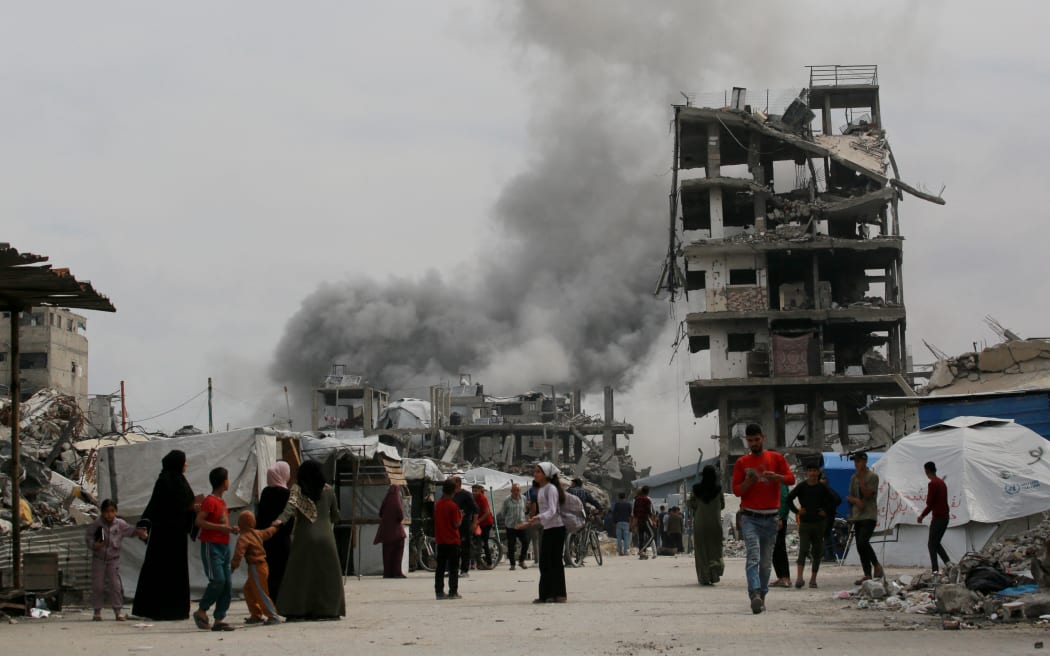 Palestinians run for cover as an Israeli strike hits the home of the Hmeid family in Jabalia in the northern Gaza Strip on 15 May, 2025.