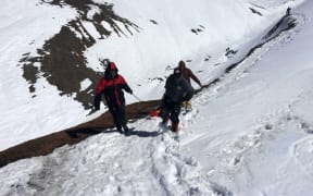 A survivor is carried on a stretcher by Nepal Army personnel to an army helicopter.