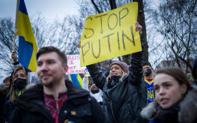 Activists hold placards and flags as they gather in Lafayette Square to protest Russia's invasion of Ukraine in Washington, DC.