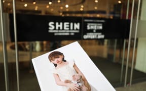 A cardboard sign bearing a photo of a child-like sex doll is placed in front of the entrance of the BHV department store, which displays the logo of the fast-fashion company Shein, embroiled in a scandal following the sale of the illustrated doll. Paris, November 3, 2025.
Un carton comportant la photo d une poupee sexuelle a l apparence d une enfant devant la porte d entree du BHV ou est affichee le logo de l entreprise de mode ephemere Shein au coeur d un scandale a la suite de la mise en vente de la poupee illustree. Paris le 3 novembre 2025. (Photo by Quentin de Groeve / Hans Lucas via AFP)