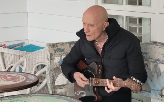 Richard O’Brien playing guitar