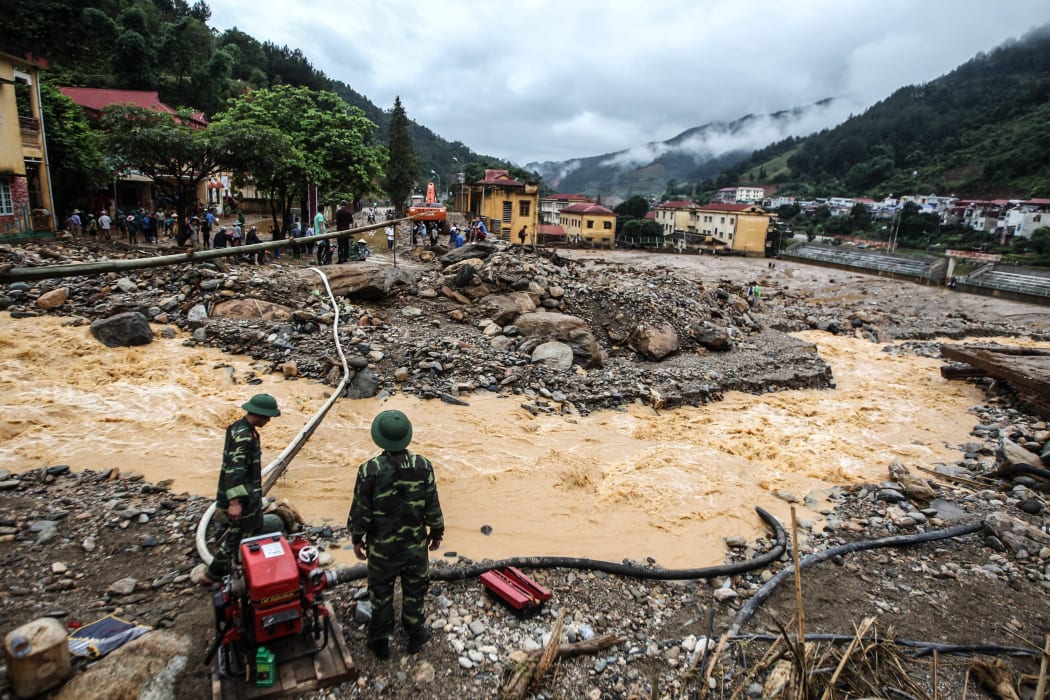 Soldiers operate a water pump amid destruction caused by flash floods in the mountainous town of Mu Cang Chai in the northern province of Yen Bai.