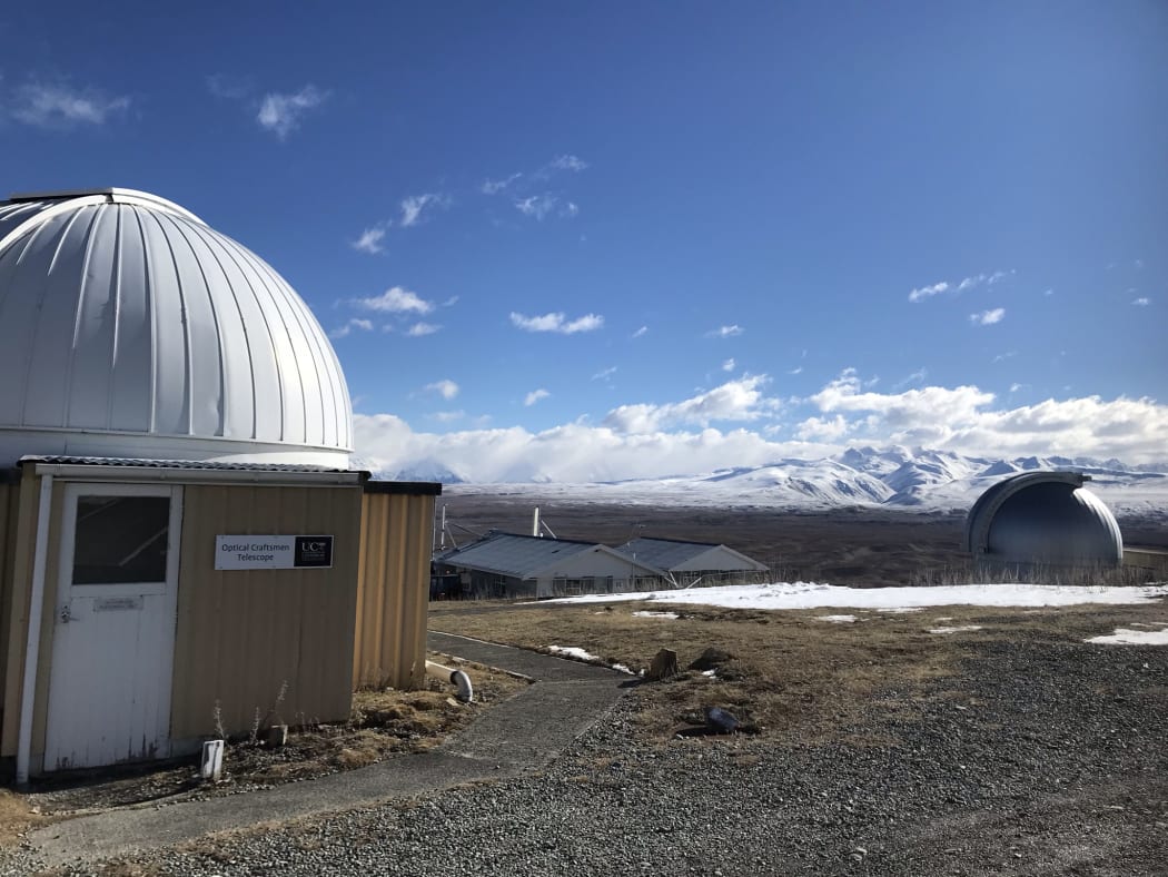 Telescopes at Mt John Observatory near Tekapo with mountains in the background.