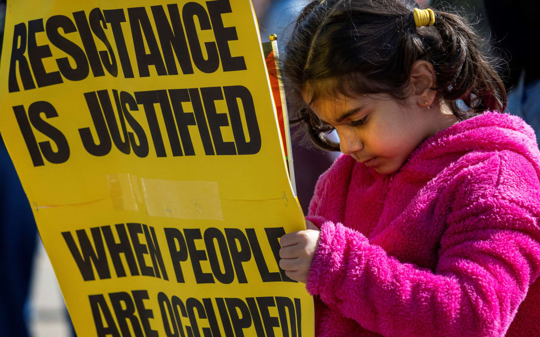 A child holds a placard as demonstrators protest outside the White House in Washington, DC, on 8 October, 2023, at a rally in support of Palestinians after the Hamas Palestinian militant group launched an assault on Israel.