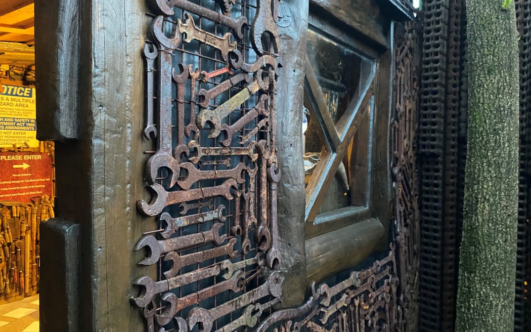 A wall of spanners leads you into a scrap metal haven full of alleyways and mountains of metal.