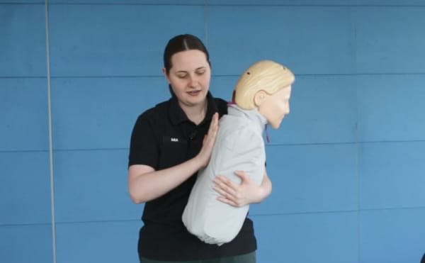 St John’s Three Steps for Life delivery lead Mia Noyes demonstrates back blows on a manikan to help someone choking.