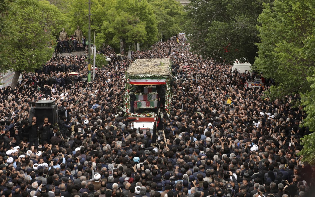 In this photo released by the Iranian Presidency Office, mourners gather around a truck carrying the flag-draped coffins of President Ebrahim Raisi and his companions who were killed in a helicopter crash on Sunday in a mountainous region of the country's northwest, in their funeral ceremony in the city of Tabriz, Iran, Tuesday, May 21, 2024. (Iranian Presidency Office via AP)