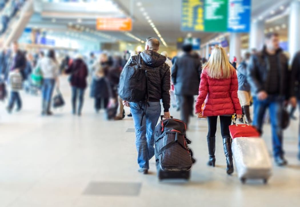 People with suitcases at airport (stock photo).