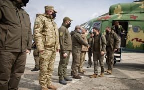 Ukrainian President Volodymyr Zelensky  shakes hands with soldiers during his visit to a front in Donbass, Ukraine.