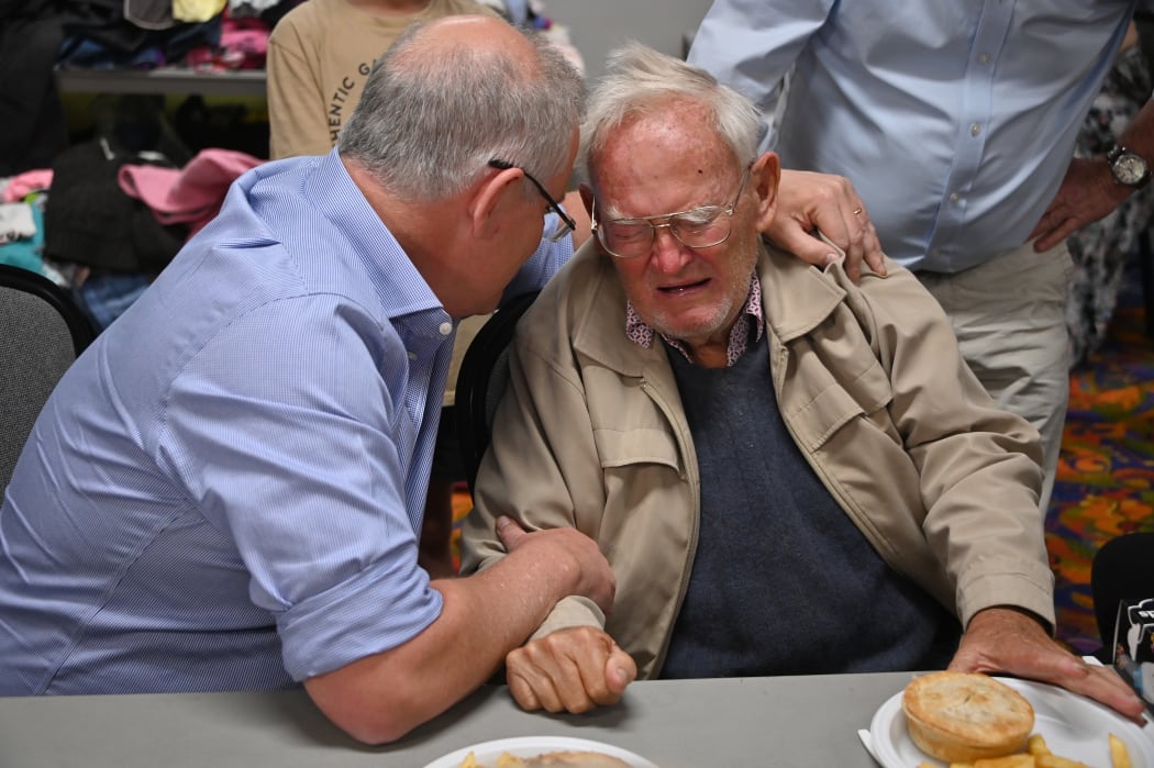Australian Prime Minister Scott Morrison comforts 85-year-old resident Owen Whalan at an evacauation centre in Taree, 350km north of Sydney, as firefighters try to contain dozens of blazes.