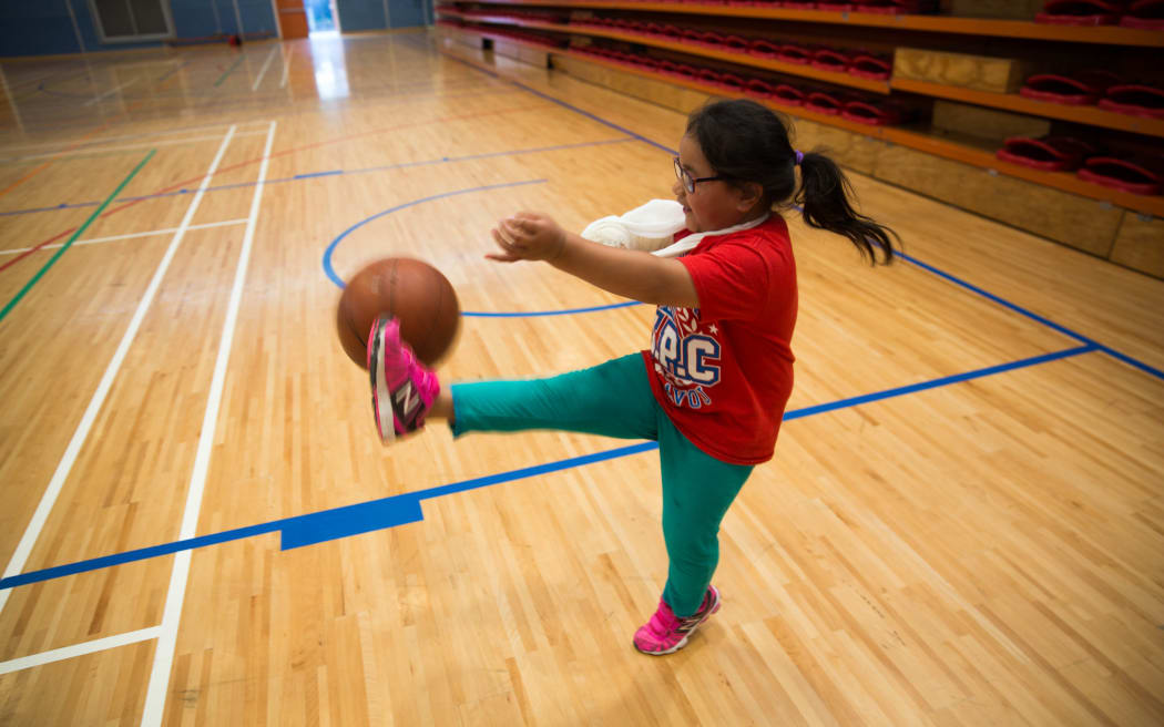 Aiga Lama playing with a basketball at the indoor courts at Otara Pool and Leisure Centre.