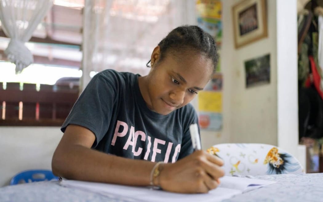 Vepaiamele writing poetry at her home in Port Vila, Vanuatu. Photo/Save the Children