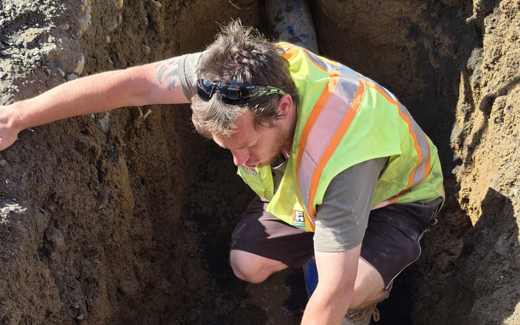 Fulton Hogan foreman Josh Lehrke checks out part of the original pipe as it's uncovered for the first time in almost a century.
