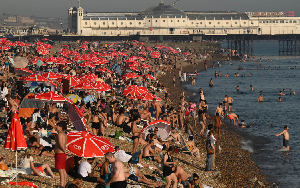 Patrząc w stronę Palace Pier, można zobaczyć plażowiczów cieszących się słońcem i morzem na plaży w Brighton, na południowym wybrzeżu Anglii, 7 września 2023 r., podczas fali upałów późnego lata.  Ubiegły miesiąc był najgorętszym wrześniem w historii "rzadki" Monitor klimatu Unii Europejskiej podał w czwartek, że latem na półkuli północnej ustanowiono rekordowe temperatury na świecie.