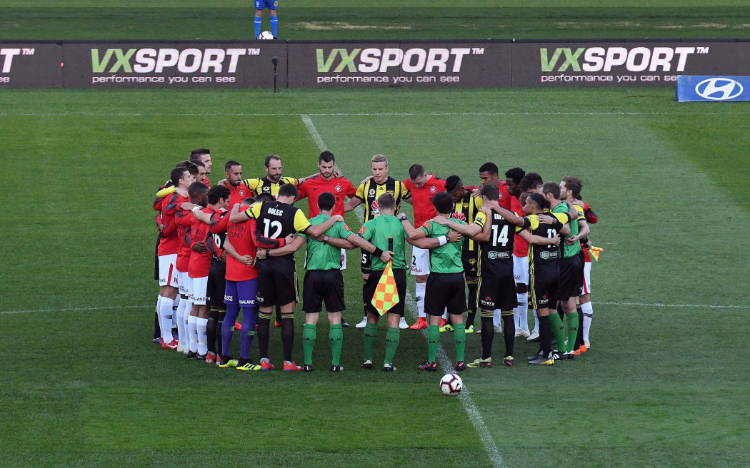 Players of Wellington Pheonix and Western Sydney Wanderers huddleup in silence in memory of the Christchurch victims during the A-League game in Wellington.