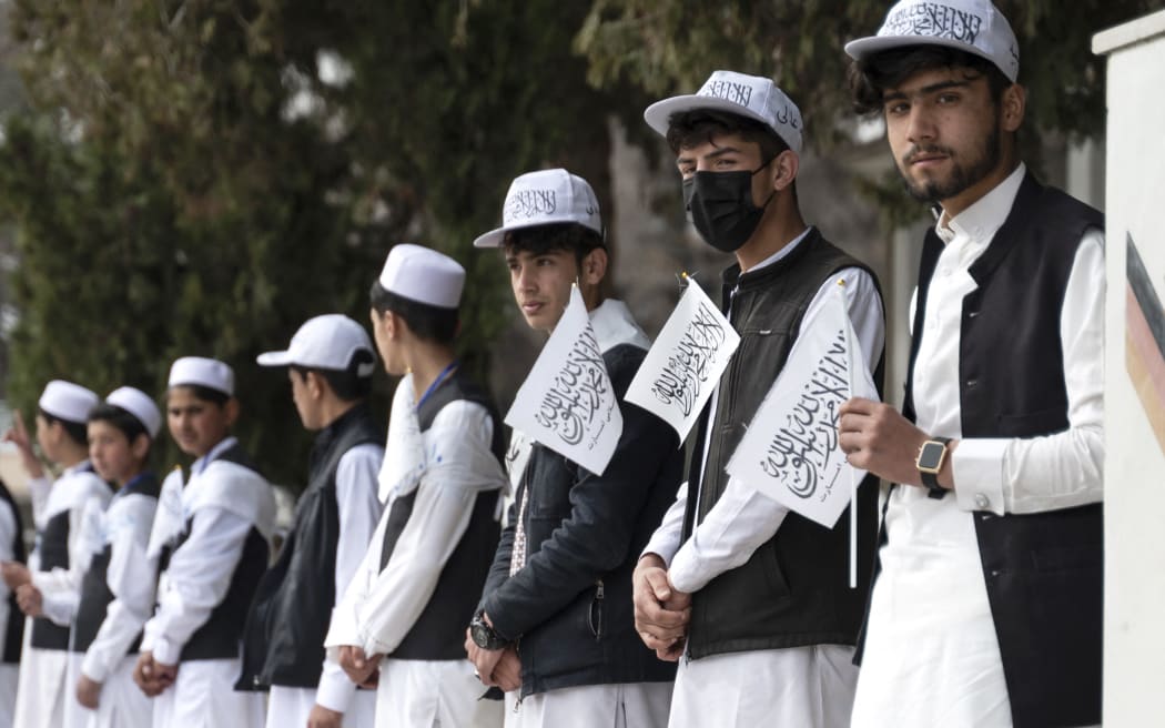 Afghan school boys holding Taliban flags align during a ceremony held to mark the start of the new academic year at Amani High School in Kabul on March 20, 2024. Schools in Afghanistan opened for the new academic year on March 20, the education ministry said, with girls banned from joining secondary-level classes for the third year in a row. (Photo by Wakil KOHSAR / AFP)
