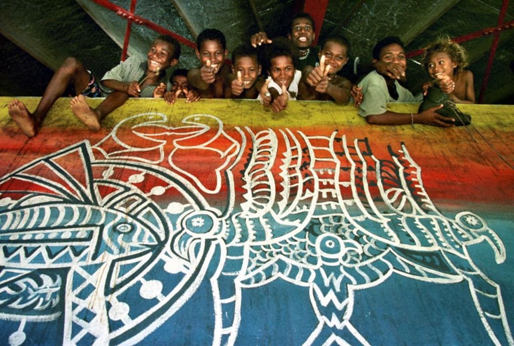 Malaitan children celebrate after reaching the relative safety of a refugee camp in Honiara, Solomon Islands 22 June 1999 after the Guadalcanal Revolutionary Army (GRA) swept through the east coast plantations.