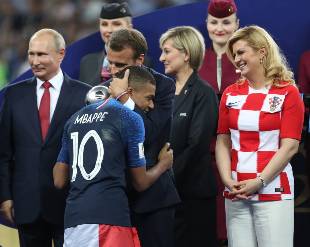 French President Emmanuel Macron embraces Kylian Mbappe at the award ceremony, with Russian president Vladimir Putin (left) and Kolinda Grabar-Kitarović, President of Croatia (right)