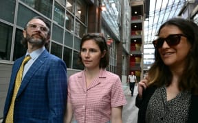 US Amanda Knox (C) arrives with her husband Christopher Robinson (L) at the courthouse in Florence, on June 5, 2024 before a hearing in a slander case, related to her jailing and later acquittal for the murder of her British roommate in 2007. The American was only 20 when she and her Italian then-boyfriend were arrested for the brutal killing of 21-year-old fellow student Meredith Kercher at the girls' shared home in Perugia. The murder began a long legal saga where Knox was found guilty, acquitted, found guilty again and finally cleared of all charges in 2015. (Photo by Tiziana FABI / AFP)