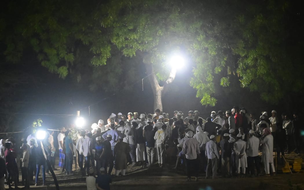 Mourners gather alongside the bodies of a former Indian member of parliament Atiq Ahmed and his brother Ashraf Ahmed after they were shot dead by gunmen outside Kalvin Hospital while being taken for a medical checkup in police custody, in Prayagraj on April 16, 2023.