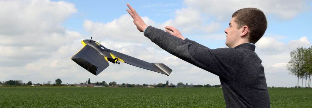 A drone pilot flies a GPS-guided aerial vehicle over a crop (above) after programming it (below) for an aerial survey of the need for nitrogen-based fertiliser in different parts of the field.
