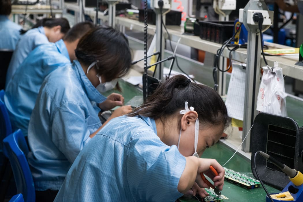 Chinese electronics factory workers in an industry manufacturing mssembly line