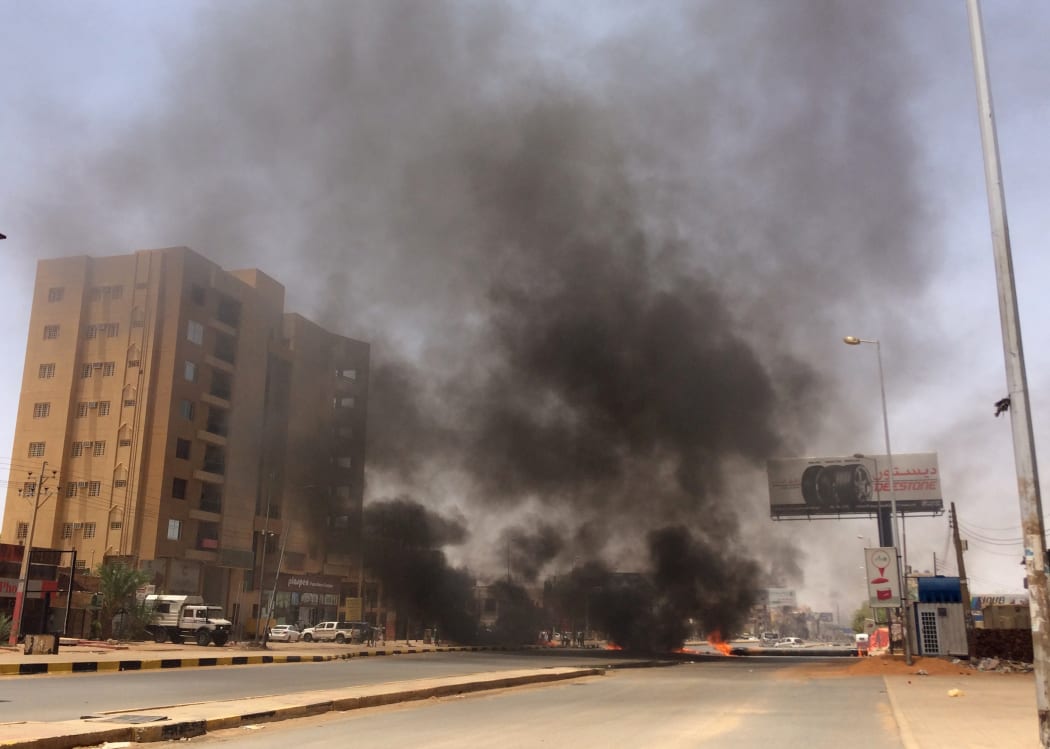 Smoke from burning tyres set alight by  protesters near Khartoum's army headquarters.