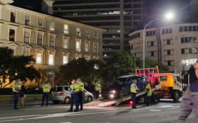 Police at the scene as a vehicle is towed late Wednesday night, near Parliament.