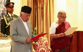 Nepal's President Ram Chandra Paudel (L) administers the oath to the country's newly appointed Prime Minister Sushila Karki during her swearing-in-ceremony at the President House in Kathmandu on 12 September, 2025.