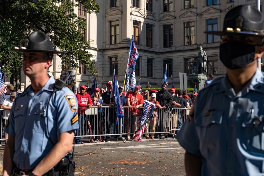 Officers stand between the protesters and counter protesters as supporters of Donald Trump host a 'Stop the Steal' protest outside of the Georgia State Capital building on November 21, 2020 in Atlanta, Georgia.