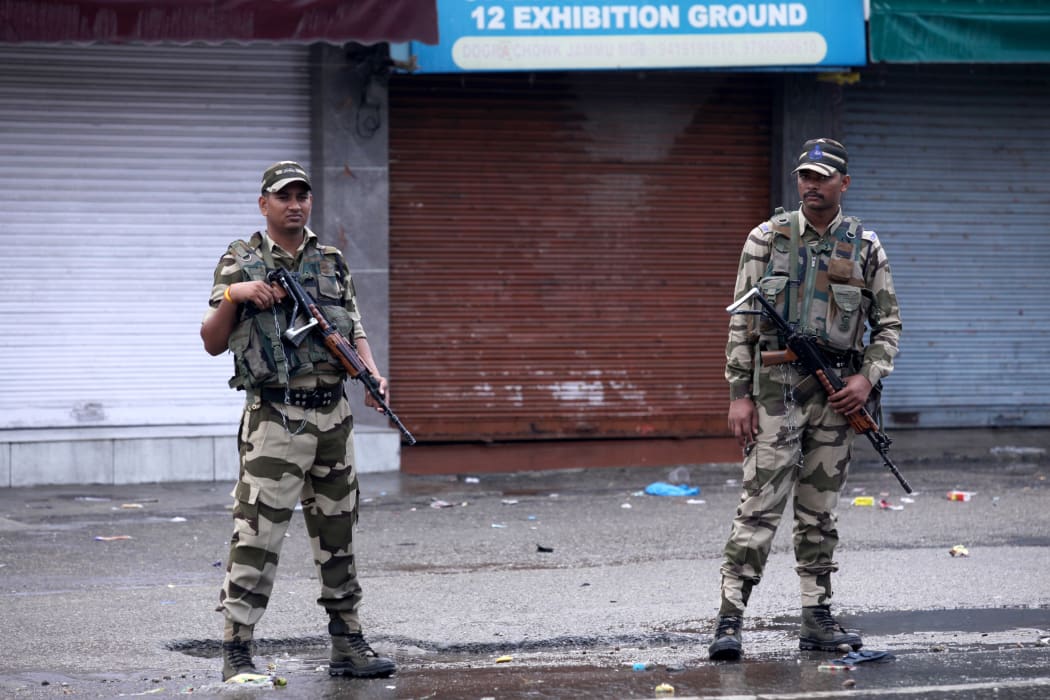 Security personnel stand guard on a street in Jammu.