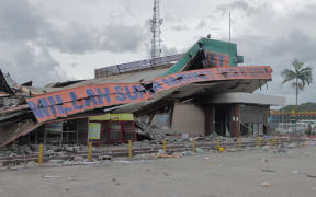 This picture shows a damaged building in Port Moresby on January 12, 2023. Troops patrolled the streets of Papua New Guinea's capital on January 12, under a state of emergency following riots that killed 16 across the country's two largest cities. (Photo by AFP)
