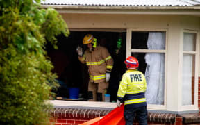 Firefighters at the scene of the smashed window.