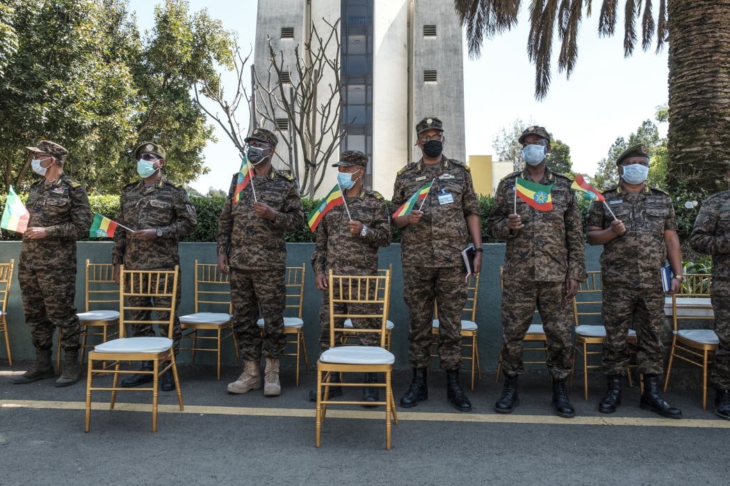 Members of the Ethiopian Army stand holding Ethiopian national flags during an event to honour the national defence forces in Addis Ababa, on November 17, 2020.