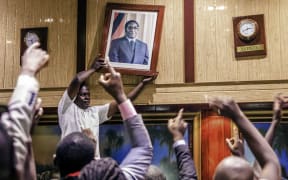 A portrait of Robert Mugabe is removed from the International Conference centre, where parliament had been sitting.