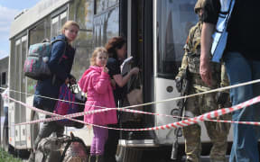 Mariupol residents leave a bus at an aid post for evacuees in Bezymennoe village, Donetsk People's Republic.