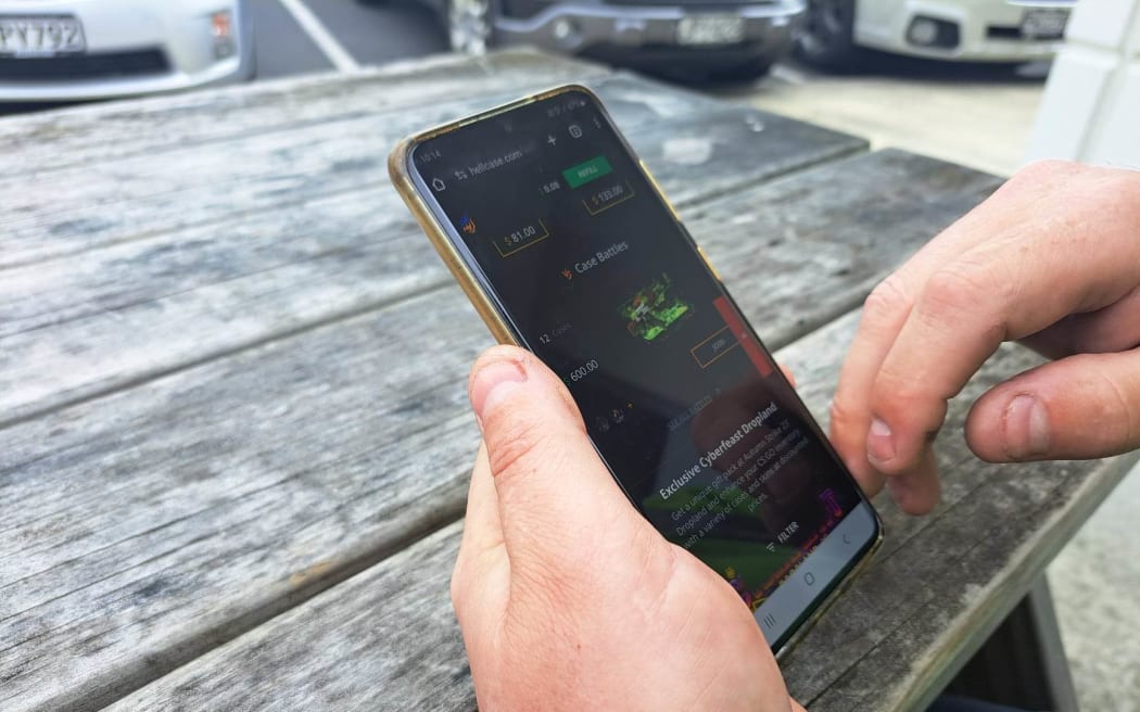 Jacques Strydom looks at Counter Strike cases on his phone.