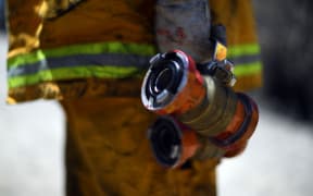 A firefighter proceeds to dose bush fire at the Woodford residential area in Blue Mountains on November 12.