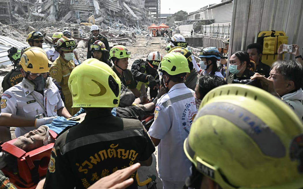 An injured man is rescued at a construction site where a building collapsed in Bangkok on March 28, 2025, after an earthquake. A powerful earthquake rocked central Myanmar on March 28, buckling roads in capital Naypyidaw, damaging buildings and forcing people to flee into the streets in neighbouring Thailand. (Photo by Lillian SUWANRUMPHA / AFP)