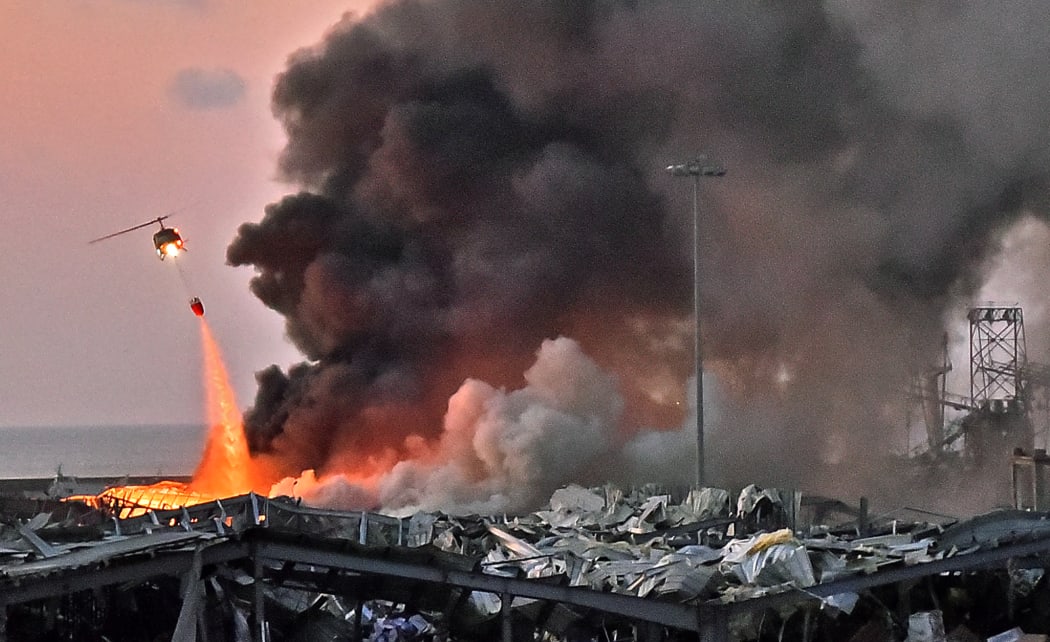 In this file photo taken on August 04, 2020 a helicopter puts out a fire at the scene of an explosion at the port of Lebanon's capital Beirut.