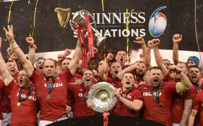 Alun Wyn Jones lifts the Six Nations Championship trophy and Jonathan Davies raises the Triple Crown. 2019.