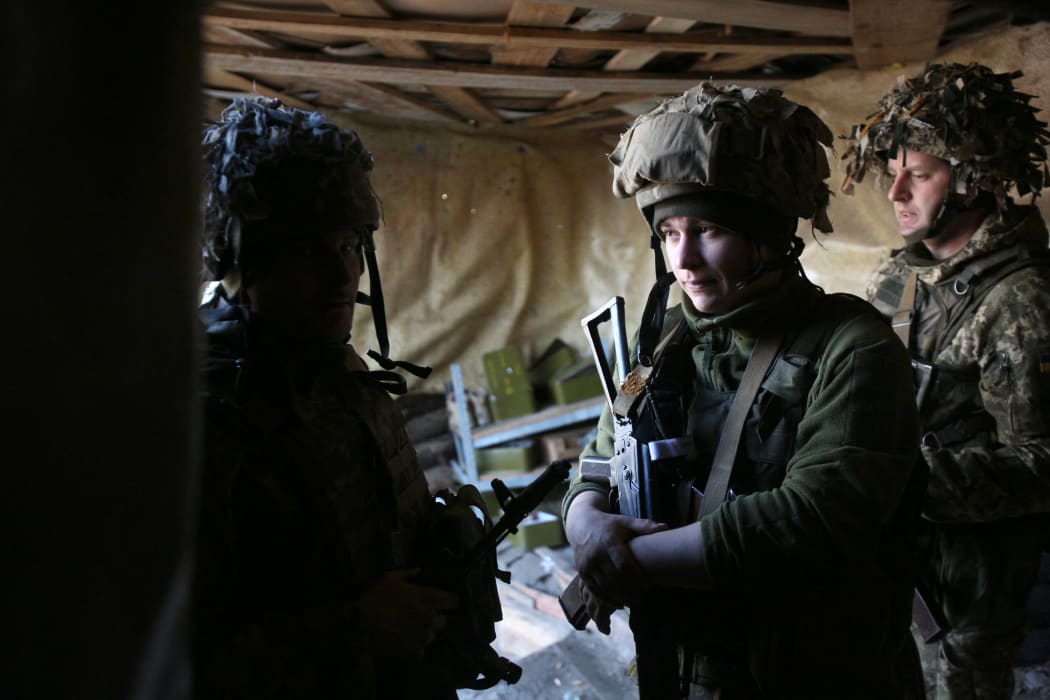 Ukrainian servicemen wait till mortar attack is over at their position on the front line with Russia-backed separatists near the town of Schastia, near the eastern Ukraine city of Lugansk, on February 23, 2022.