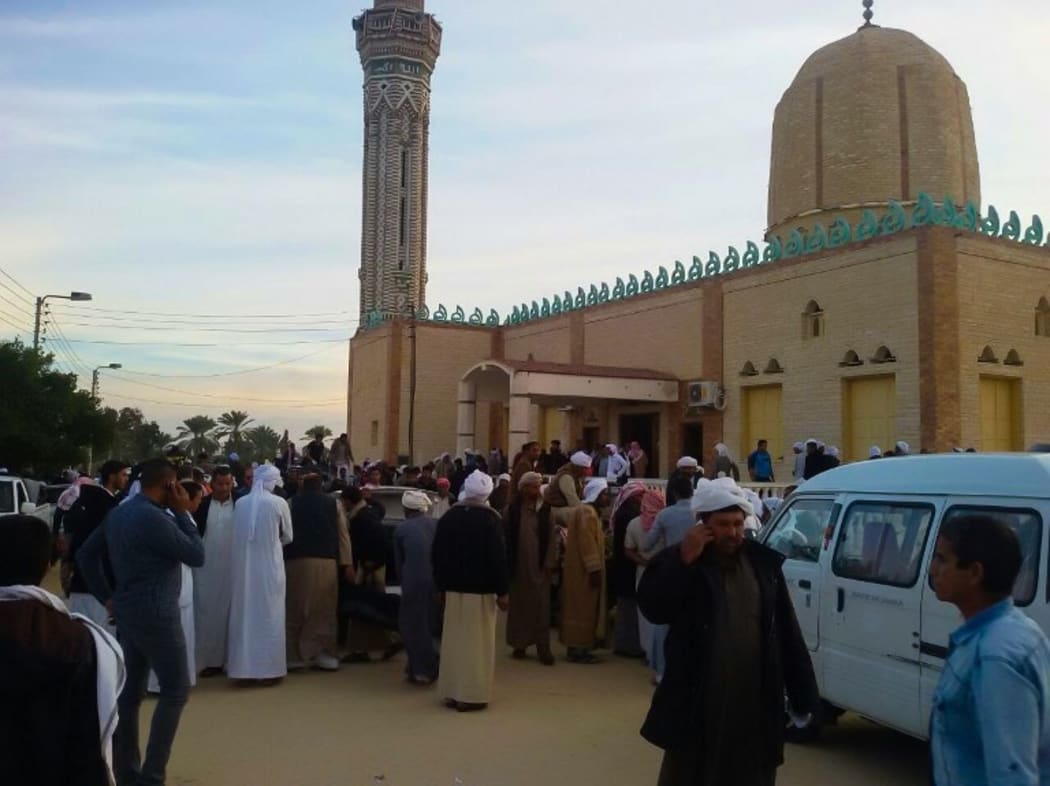 People gather at the site of the Egypt Sinai mosque bombing in Al-Arish, Egypt.