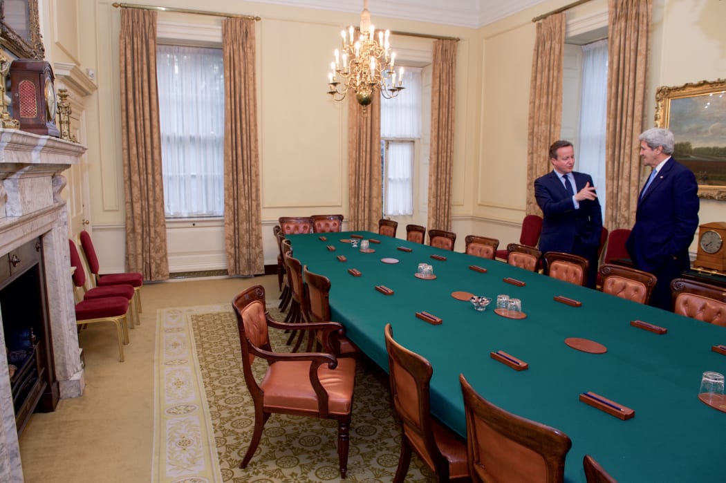 British Prime Minister David Cameron shows U.S. Secretary of State John Kerry the Cabinet Room at 10 Downing Street. The PM's chair angled for easy access.