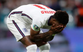 No captionEngland's Marcus Rashford reacts after failing to score a penalty during a shootout at the end of the Euro 2020 final at Wembley stadium.