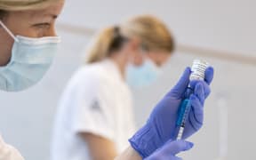 A nurse wearing gloves holding a syringe which is being filled with Covid-19 vaccine made by AstraZeneca in Malmo, Sweden
Photo: Johan Nilsson / TT / Code 50090