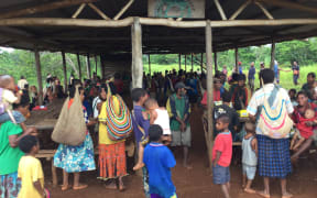 Villagers in PNG's Western Province gather around an empty market place normally filled with fresh produce.